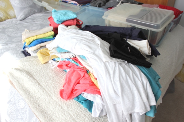 clothes piled on bed